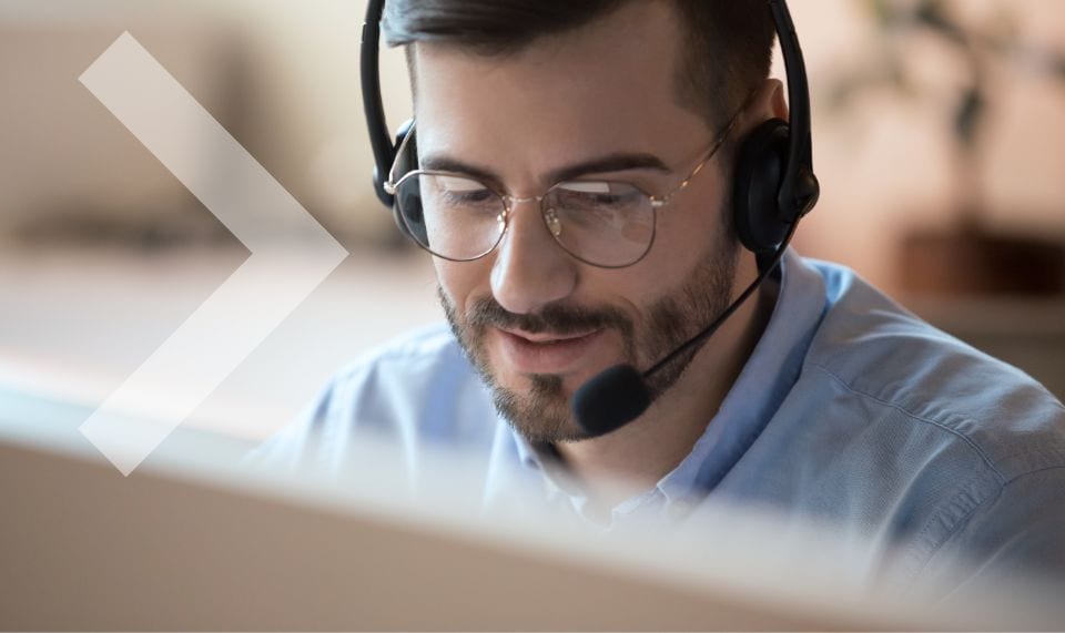 a man with a headset on in front of a computer